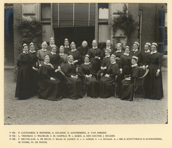 826481 Groepsportret van diaconessen in de tuin van het Diakonessenhuis (Oudegracht 419-421) te Utrecht. Vooraan ...